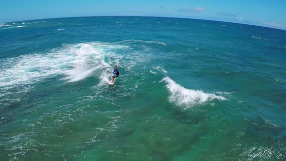 Aerial view of a man kitesurfing in Hawaii.