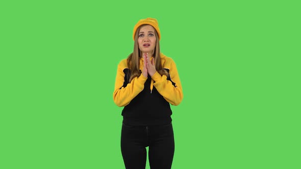 Modern Girl in Yellow Hat Is Looking with Sympathetically, Folded Arms. Green Screen