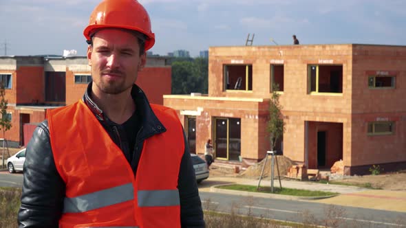 A Young Construction Worker Points at the Camera and Nods