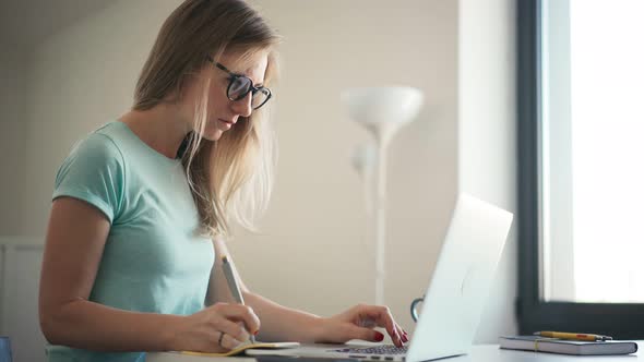 Young Adult Woman in Glasses Working on a Laptop From Home