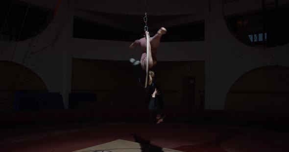 Two Aerial Gymnasts Are Doing a Split on a Hoop Hanging Upside Down