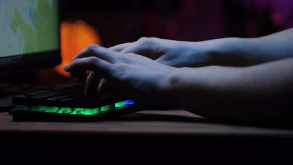 Gamer Typing on Backlight Keyboard Closeup Man Playing Video Game