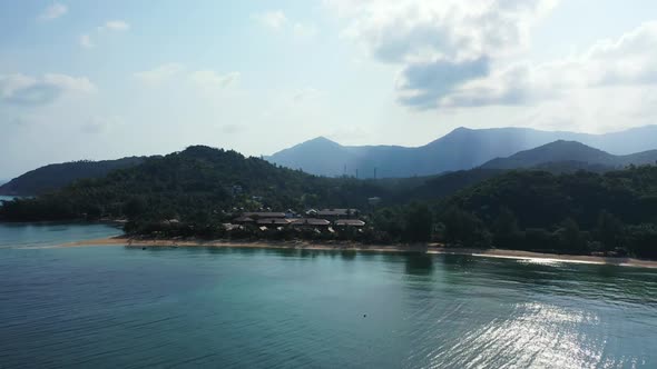 Aerial top down panorama of tranquil sea view beach adventure by transparent lagoon with white sandy