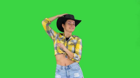 Young Lady in a Cowboy Hat Dancing on a Green Screen, Chroma Key.