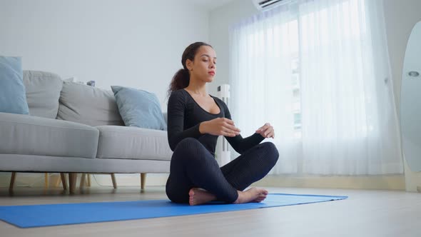 Latino young beautiful active woman doing Yoga Pilates workout at home.