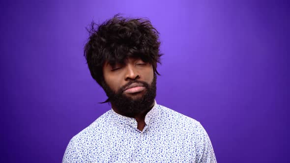 Regretful African American Man Shaking Head and Sighing Purple Background