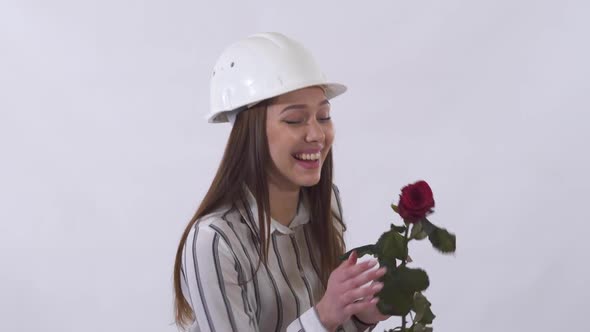 Joyful Beautiful Woman in White Helmet Holding a Red Rose in Her Hands and Very Happy Isolated