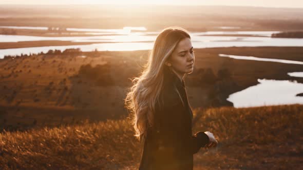 Young Woman in Black Clothes Training with a Sword While Early Sunset on Nature