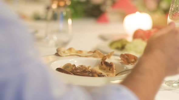 Festive table with appetizers and man hands  with food and drinks in a restaurant.