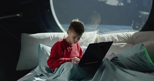 Boy Using Laptop in Spaceship