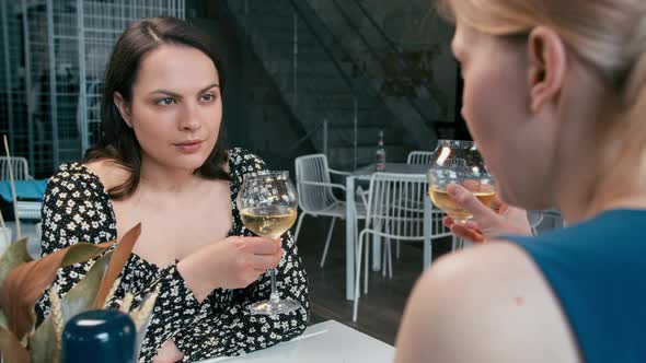 Girl in Shock at the News Two Girlfriends Gossiping in a Cafe