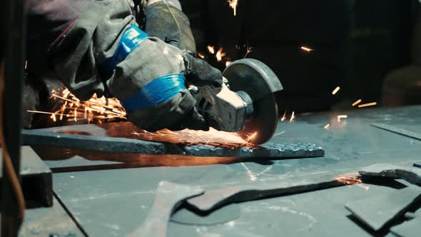 Man Works with Circular Saw. Sparks Fly From Hot Metal. Man Hard Worked Over the Steel. Industrial