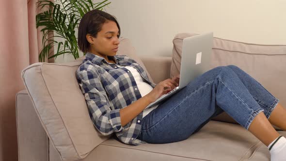 A Woman Works at Home Online Using a Laptop a Hand Hands Her a Cup of Coffee