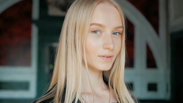 fashion portrait of a beautiful young woman with blue eyes and blonde hair in a leather jacket indoo