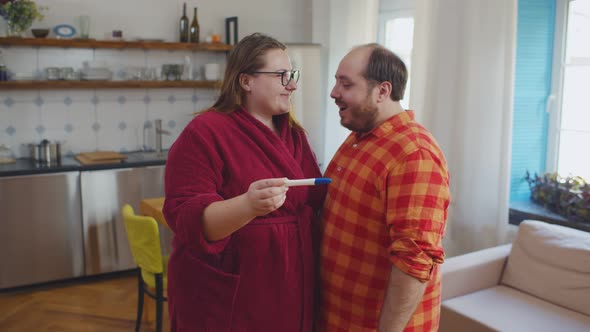 Overweight Couple Happy With Positive Result of Pregnancy Test Hugging And Smiling