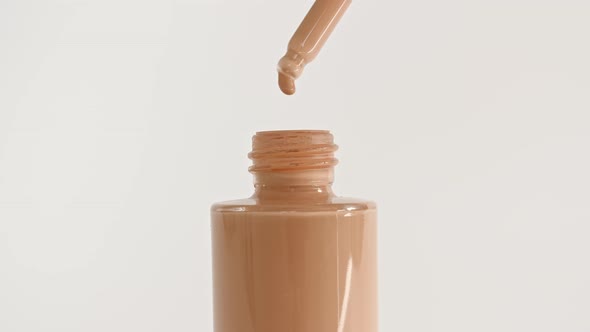 Foundation for Face Concealer Cosmetic Liquid Foundation Drips From a Pipette Into a Bottle