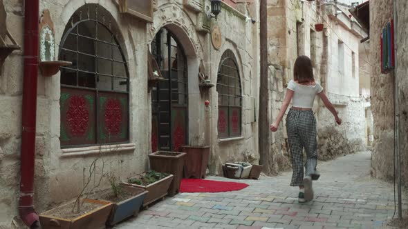 Girl Walking Away with Dance By Narrow Street Old Town