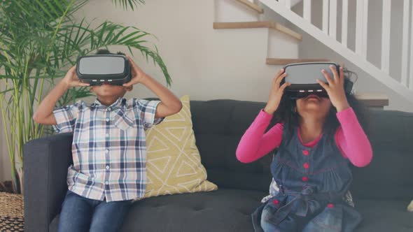 African american siblings wearing vr headsets and having fun