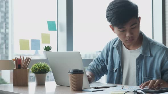 Young man working on his laptop in office.