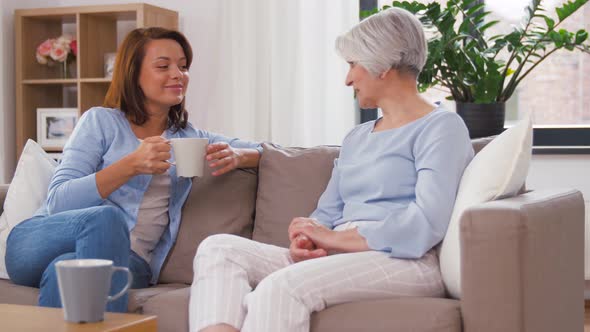 Senior Mother and Daughter with Coffee Talking 