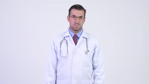 Young Stressed Hispanic Man Doctor Giving Thumbs Down