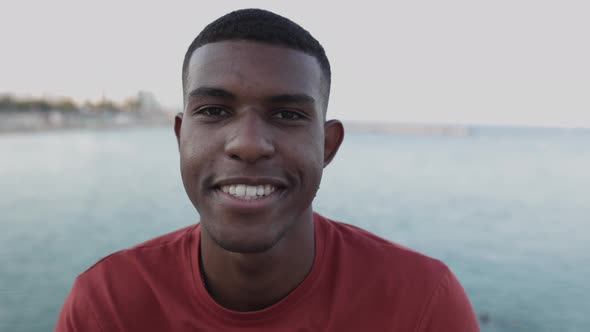 Close Up Portrait of Smiling Brazilian Man Looking at Camera By the Sea