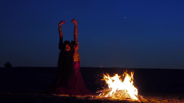 Late Night a Girl in the Sand Dancing Belly Dancing Near a Bright Campfire