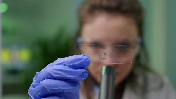 Closeup of Chemist Scientist Looking at Green Leaf Sample Checking Genetic Mutation