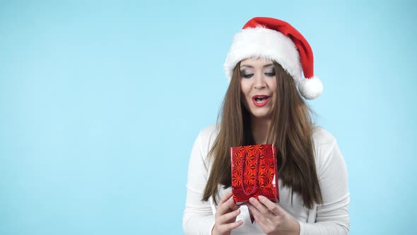 Girl in Santa Hat Received Gift. Christmas