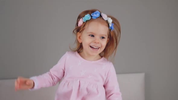 Cute happy little girl jumping on bed