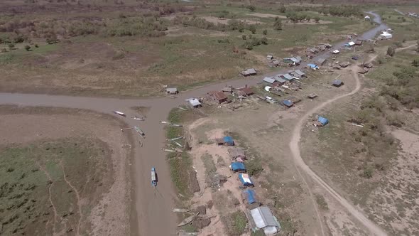 Aerial view of small boat sailing on mud canal, Tonle Sap, Cambodia.