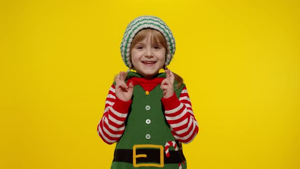 Christmas wish concept Kid teen girl in Christmas elf Santa helper costume making a wish, prays