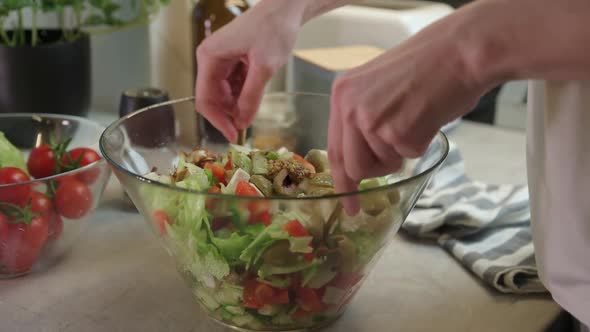 Woman Mixing Green Vegetable Salad in Bowl at Kitchen