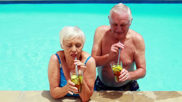 Senior couple interacting with each other while having glasses of iced tea