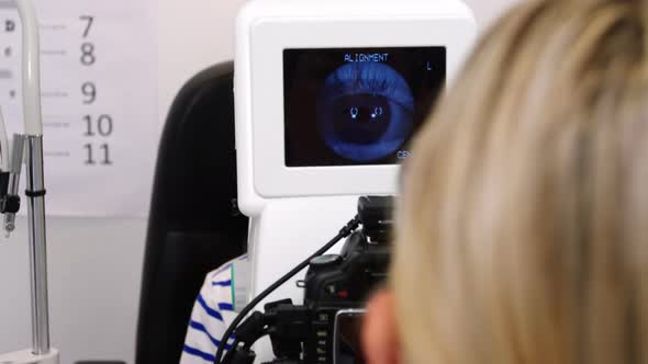 Female optometrist examining young patient on coreometry