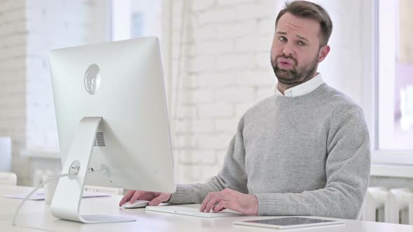 Shocked Young Man Looking Toward Camera at Work