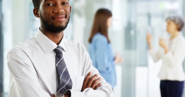 Businessman standing with arms crossed in office