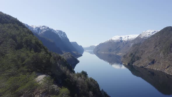 Mesmerizing view of calm and silent water channel amidst huge snow laden mountains. Forward moving a