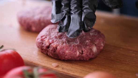 Woman Chef in Black Gloves Prepares Cutlets at Domestic Kitchen on a Wooden Cutting Board