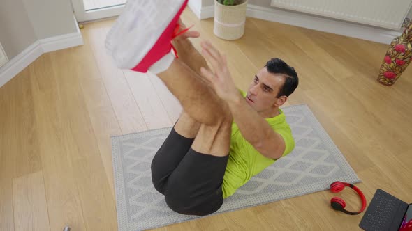 High Angle View of Muscular Middle Eastern Sportsman Reaching Tiptoes with Hands Lying on Exercise