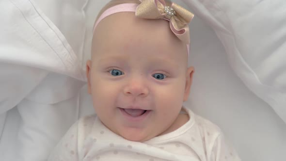 Portrait of Smiling Blue-eyed Baby Girl of Six Months Old