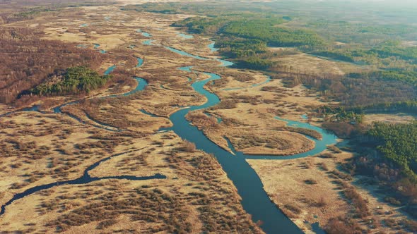 Aerial View Of Forest Woods And Partly Frozen River Landscape In Sunny Late Autunn Day