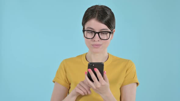 Young Woman Using Mobile Phone on Purple Background 