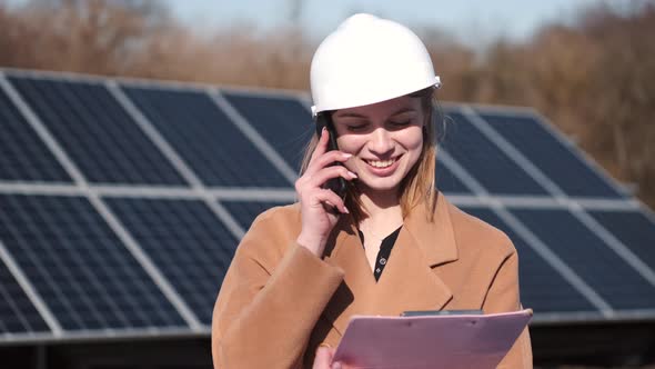 Woman Technician at Solar Station Talking on Phone