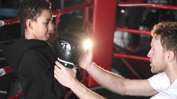 Boy Boxer Practicing Punches with His Coach at Gym