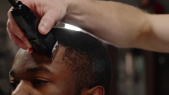 White Guy Doing a Haircut to a Young Joyful African American Guy in a Beautiful Barbershop