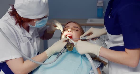 A Dentist Applies a Retractor to Patient Before Professional Teeth Cleaning