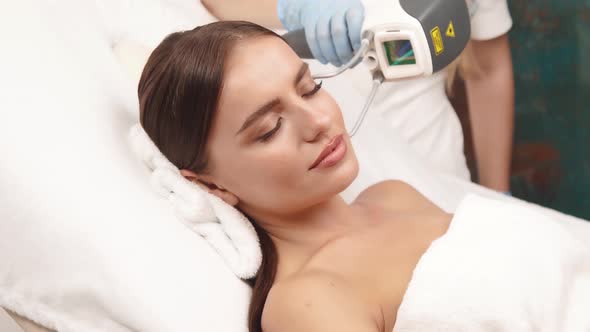 Cosmetologist Working on Female Face with Professional Laser