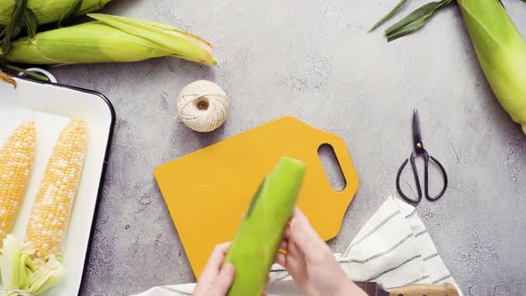 Step by step. Shucking organic corn to make Mexican corn on the cob Elote.