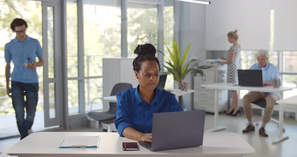 Young Man Entering Office and Bringing Takeaway Coffee to Female Colleague